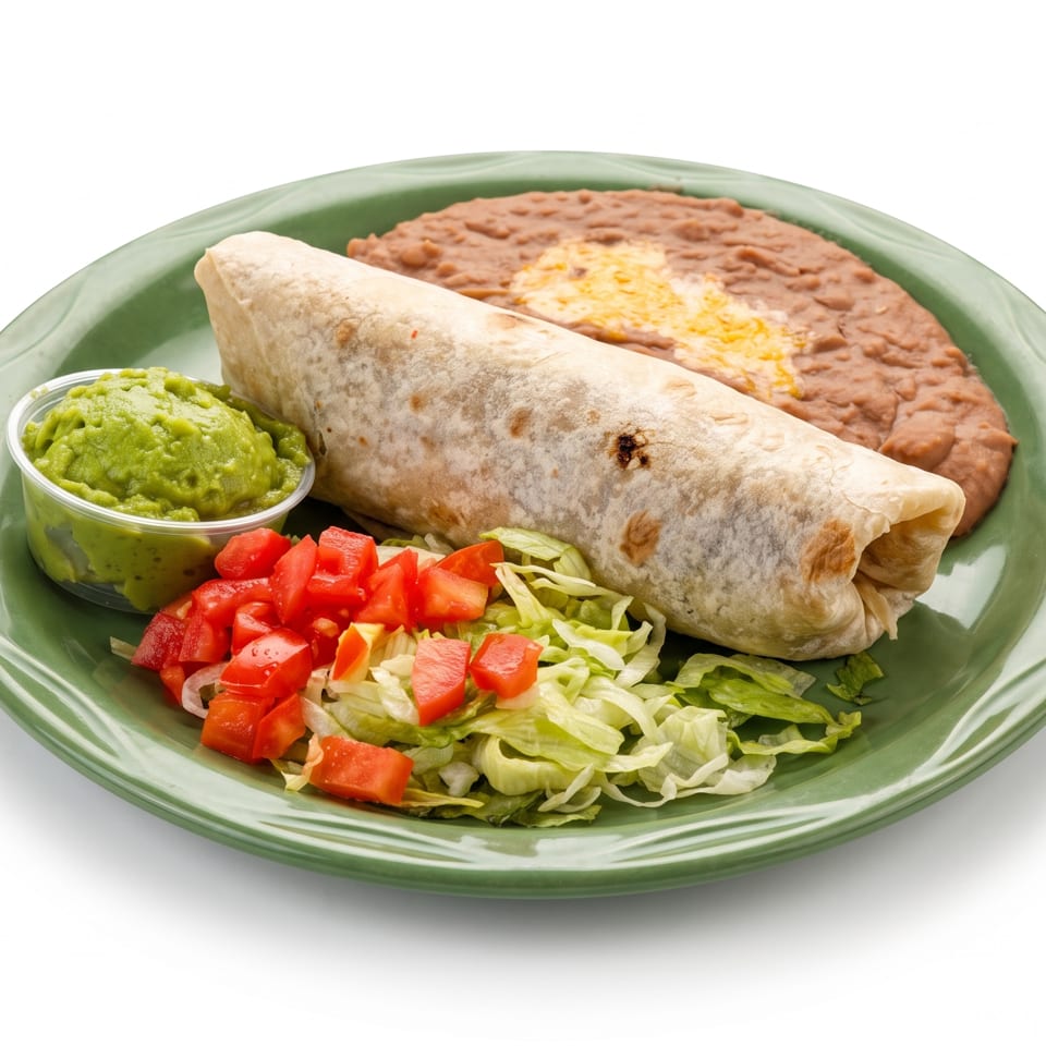 Burrito plate with refried beans, guacamole, shredded lettuce, and diced tomatoes on a green dish.