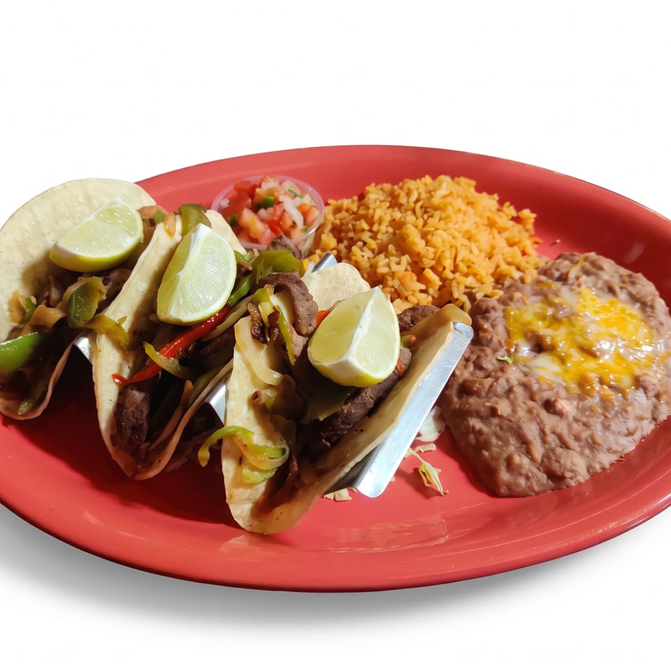 Red plate with three beef tacos, lime wedges, Mexican rice, refried beans topped with melted cheese, and pico de gallo.