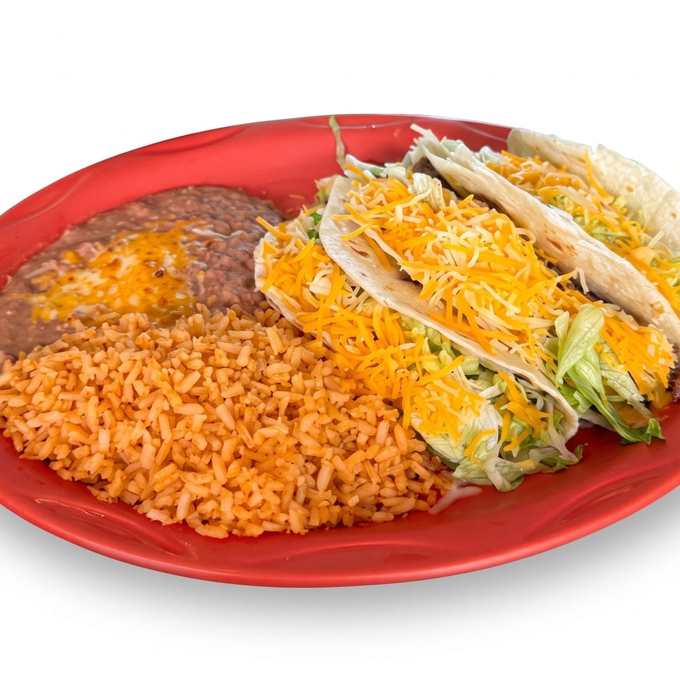 Red plate holding two beef tacos with lettuce and shredded cheese, Mexican rice, and refried beans.